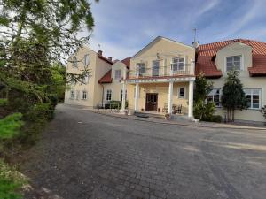 a cobblestone street in front of a white house at Dworek Bursztynowe Piaski in Gdańsk