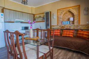 a kitchen and a living room with a table and a couch at Laura Beach House in Alykes
