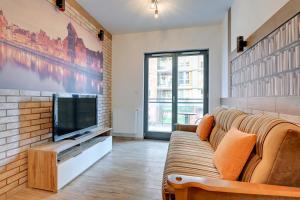 sala de estar con sofá y TV en Old Town Torunska en Gdansk