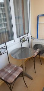 a table and two chairs in a room with a window at ARANYHÍD APARTMAN in Siófok