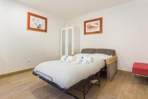 2 camas individuales en una habitación con silla roja en CMG Porte de Châtillon - Malakoff V, en Malakoff