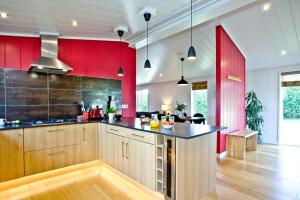 a kitchen with red walls and a counter top at Pomegranate, Strawberryfield Park in Cheddar