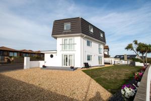 een wit huis met een zwart dak bij Deluxe Modern House with Sea views and beach 300 footsteps away in Bournemouth