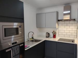 a kitchen with a sink and a microwave at 1 WATER PUMP HOUSE in Bury Saint Edmunds +7 photos