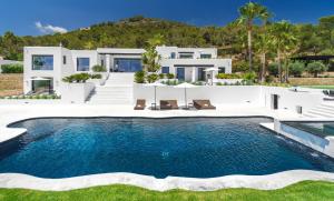 a villa with a swimming pool in front of a house at Luxury Villa with Superb Sea Views, Ibiza Villa 1054 in Nuestra Señora de Jesus