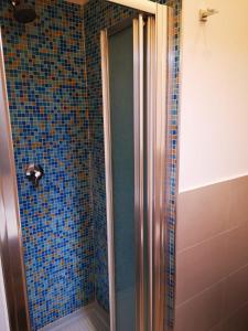 een badkamer met een douche met blauwe tegels bij Casa Cupiello Via Chiaia - Casa Vacanze ad uso Esclusivo in Napels
