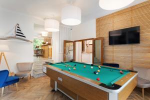 a living room with a pool table and a tv at Dom wakacyjny Cyprys in Jastrzębia Góra
