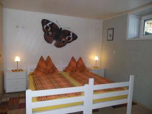 - une chambre dotée d'un lit avec un papillon sur le mur dans l'établissement Haus Cornelia, à Mallnitz