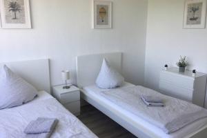 two beds in a room with white walls at Komplett ausgestattetes Apartment in Dormagen in Dormagen +4 photos