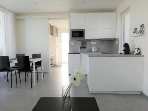 a white kitchen with a table and a vase with a flower at Apartmán Polička in Polička