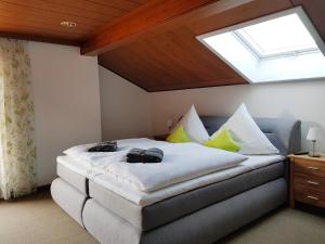 ein Schlafzimmer mit einem Bett mit gelben Kissen und einem Dachfenster in der Unterkunft Ferienhaus am Höldersberg in Sonthofen
