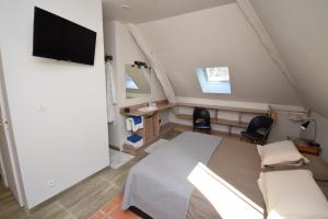 a bedroom with a bed and a tv on a wall at Le Moulin de Planiol in Le Vigan