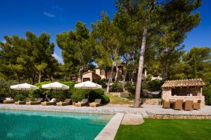 a swimming pool with chairs and umbrellas next to a house at This Luxury Villa is Fully Staffed, Mallorca Villa 1021 in Banyalbufar