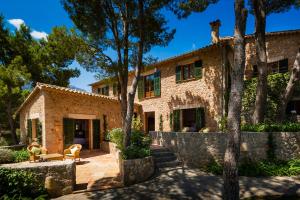 an exterior view of a stone house with trees at This Luxury Villa is Fully Staffed, Mallorca Villa 1021 in Banyalbufar