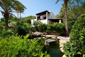 una casa en medio de un jardín con un estanque en Luxury Private Holiday Villa with Private Pool, Ibiza Villa 1077, en Santa Eulària des Riu
