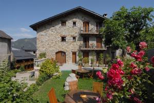 an old stone house with a table and flowers at Hotel Casa Cornel in Cerler