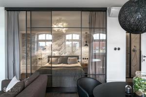 a bedroom with a bed with a glass wall at Blue Mandarin Old Town in Gdańsk