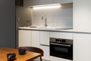 a kitchen with a table and a sink and a stove at The Gate London City in London