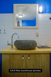 a bathroom counter with a stone sink and a mirror at Atlas Private Guesthouse in Bruges