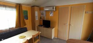 Cette petite chambre comprend une table et une télévision. dans l'établissement Mobil-home au pied des Pyrénées, à Castillon-en-Couserans