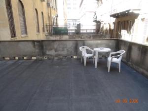 ジェノヴァにあるゲストハウス ラ ブリオサ ニコールの白い椅子2脚、バルコニー(テーブル付)