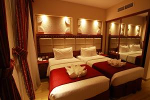 Giường trong phòng chung tại Al Liwan Suites Rawdat Al Khail