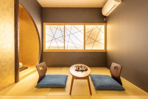 京都市にあるTABITABI STAY 東山「HIGASHIYAMA」のテーブルと椅子2脚と窓のある部屋