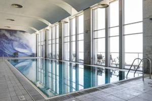 a swimming pool in a building with windows at Luxury Condo & Spectacular View by FeelHome in Tel Aviv