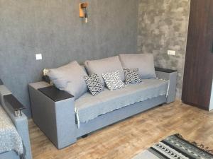 ein Sofa im Wohnzimmer mit Kissen drauf in der Unterkunft Однокімнатна квартира-студія біля парку Шевченка in Iwano-Frankiwsk