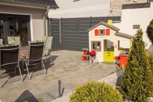 eine Terrasse mit einem Spielzeughaus und einem kleinen Haus in der Unterkunft Familienfreundliches Ferienhaus in Kröpelin in Kröpelin