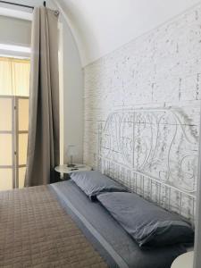 ポリニャーノ・ア・マーレにあるZI' MARI' - Via Romaの白レンガの壁のベッドルーム1室