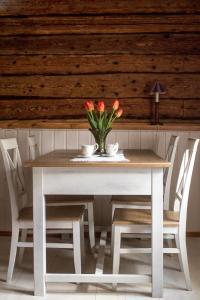 a white table with a vase of flowers on it at Wiedemanni Apartment in Haapsalu