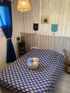 a bedroom with a bed with a blue and white comforter at Appartements La Durance et L'Helpe in Embrun