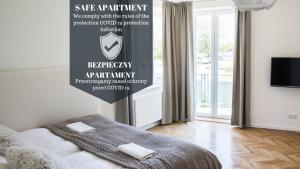 sypialnia z łóżkiem z napisem na ścianie w obiekcie Apartment Nearto Old Town Na Ustroniu street w Krakowie