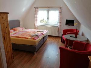 Schlafzimmer mit einem Bett, einem Tisch und Stühlen in der Unterkunft Pension und Bistro" Dat olle Fischerhus" in Ralswiek