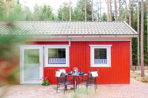 einem roten Schuppen mit einem Tisch davor in der Unterkunft Waldhaus Emma in Suderburg