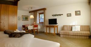 a hotel room with a dog laying on a bed at Raschötzhof in Funes