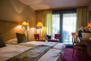 une chambre d'hôtel avec un lit, une table et des chaises dans l'établissement Le Moulin de la Walk, à Wissembourg