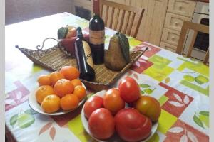 una mesa con dos platos de fruta y una botella de vino en Casa Playa los Percheles, en Puerto de Mazarrón