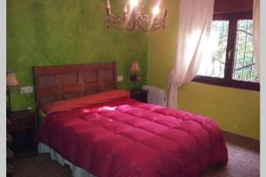 una camera da letto con un letto con un piumone rosso e una finestra di Casa Playa los Percheles a Puerto de Mazarrón