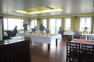 a group of people sitting at tables in a restaurant at Thai Binh II Hotel in Hue