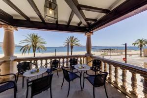 balcón con mesas y sillas y vistas a la playa en Beach Villa Silver by Sealand Villas, en Puerto Pollensa