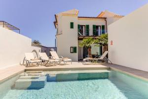 una piscina con sillas y una casa en Beach Villa Silver by Sealand Villas, en Puerto Pollensa