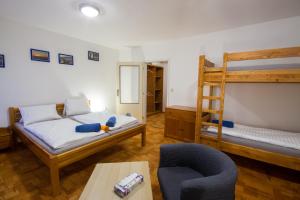 a bedroom with two bunk beds and a chair at Modrý pension in Rokytnice nad Jizerou