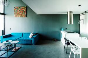 sala de estar con sofá azul y mesa en Athina Art Apartments, en Atenas