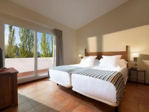 a bedroom with a large bed and a large window at Hotel Fuerte Grazalema in Grazalema