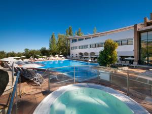 una piscina en un hotel con sillas y sombrillas en Hotel Fuerte Grazalema, en Grazalema