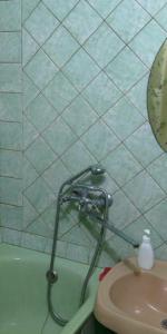 a bathroom with a shower nozzle next to a sink at Уютная квартира рядом с метpo Холодная гора in Kharkiv