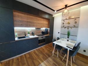 a kitchen with a table and chairs and a sink at Nowy Apartament 58 z klimatyzacją in Iława