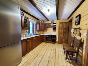 a large kitchen with wooden floors and wooden cabinets at На Галіції in Kichera